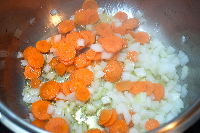 Cebolla picada y zanahoria dentro de la olla