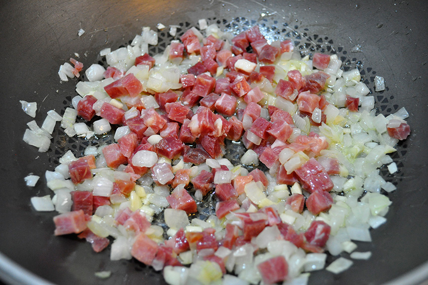 Sofriendo el jamón con la cebolla y el ajo
