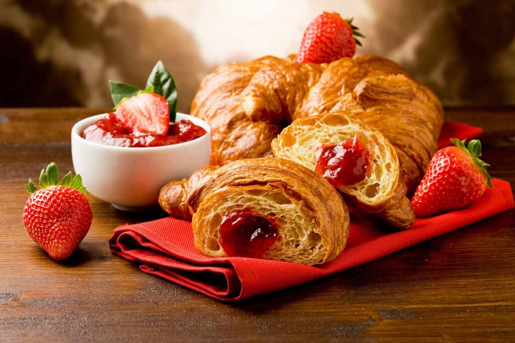 Croissant relleno de mermelada de fresa.