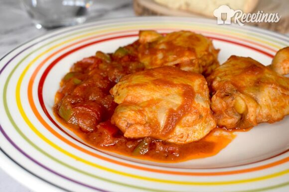 Pollo guisado con pimientos en salsa de tomate
