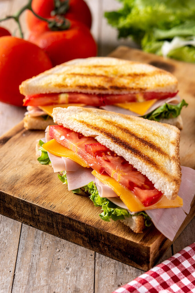 Presentación de Sándwich de tomate, jamón y queso